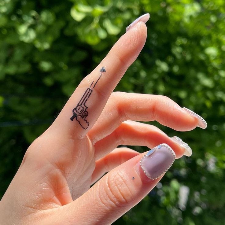 Gun finger tattoo